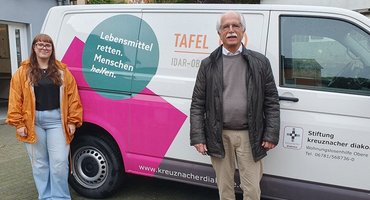 Zwei ehrenamtliche Helfer (eine Frau und ein Mann) stehen vor dem neuen Transporter der Tafel Idar-Oberstein, Wohnungslosenhilfe der Stiftung kreuznacher diakonie